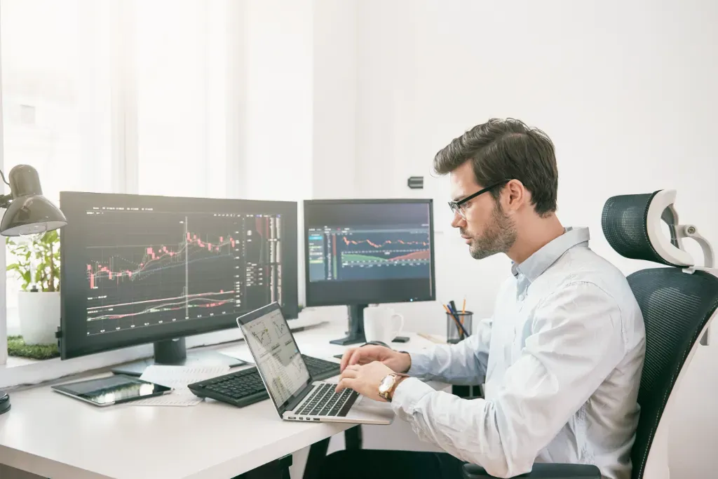 Mężczyzna siedzi przy biurku z laptopem